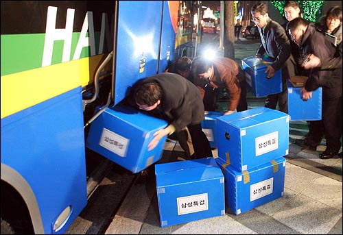 삼성특검 수사관들이 25일 저녁 서울 중구 삼성화재 본사에서 압수한 물품을 관광버스 화물칸에 차곡차곡 쌓고 있다.
