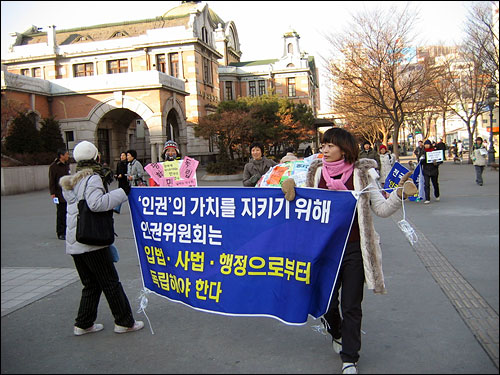 '세계 행동의 날' 행사에 참여하기 위해 서울역 광장으로 오고 있는 사람들. 국가인권위원회의 독립을 주장하는 내용의 문구가 눈길을 끈다.