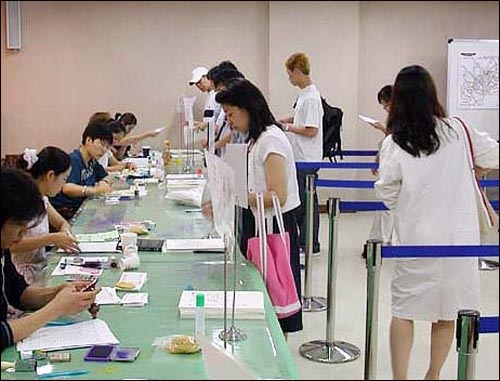 토익 시험에 응시하려는 사람들이 서울 종로에 마련된 접수처에 원서 접수를 하고 있다(자료 사진).