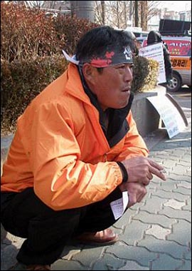 시위에 지친 성승현(50)씨가 길가에서 담배를 피우고 있다.