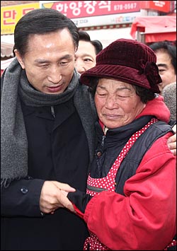 지난 3일 오후 서울 관악구 봉천11동 원당시장을 방문한 이명박 당선인이 생선을 파는 김성림(67)할머니가 장사가 어렵다고 울며 하소연하자 위로의 말을 건네고 있다.