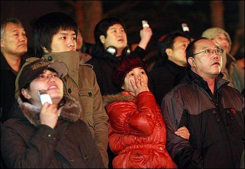 10일 밤 서울 숭례문에서 화재가 발생해 시민들이 무너져 내리는 숭례문을 바라보며 안타까워 하고 있다.