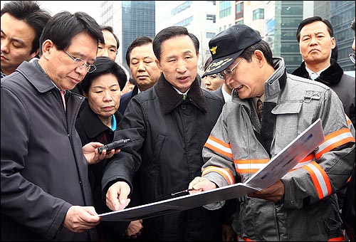  이명박 대통령 당선자 등 인수위 위원들이 11일 오전 서울 숭례문 화재현장을 방문해 정정기 서울소방재난본부장으로 부터 상황 설명을 듣고 대책 등을 지시하고 있다.