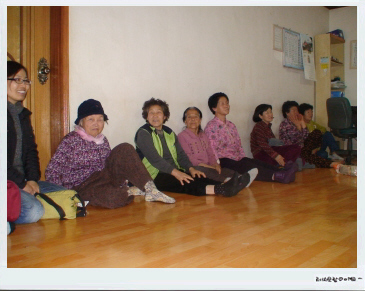 마을회관에 할머니들이 모여 티브이를 보고 있다. 