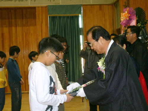 장우현 교장선생님이 졸업생들에게 졸업장을 수여하고 있다.