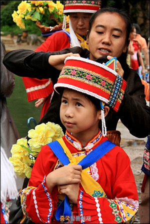 아스마스 앞 연못에서 이족 전통 옷을 입고 있는 아이