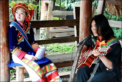 쿤밍 소수민족촌에서 기타를 치며 노래하고 있는 라후족 총각과 처녀