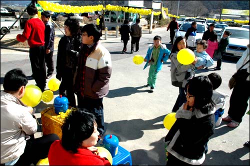 노사모 회원들이 관광객들에게 노란 고무풍선을 만들어 나눠주고 있다.