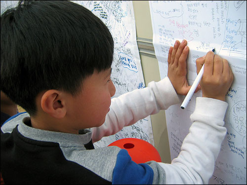 숭례문 앞에서 글을 쓰는 섬진강 어린이.