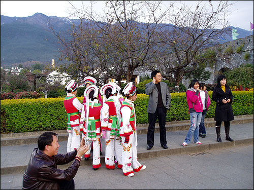 바이족 복장을 한 아가씨들이 관광객과 사진을 찍기 위해 기다리고 있다