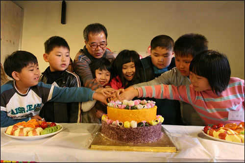 <오마이뉴스> 연중기획 '저자와 한밤을 보내다' 첫번째 순서인 '섬진강 어린 시인들을 만나다' 행사에서 출판기념회를 열었다. 지도교사인 김용택 시인과 어린 시인들이 함께 케이크 커팅을 하는 모습.