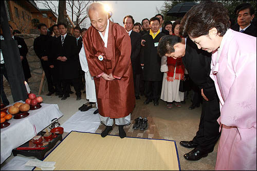 노무현 전 대통령이 부인 권양숙씨와 함께 25일 오후 고향인 김해 봉하마을에 도착해 사저에 들어가기에 앞서 예를 올리고 있다.