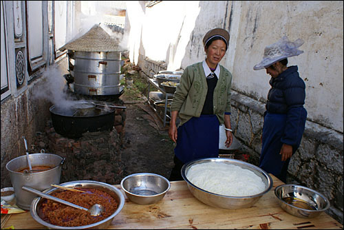 결혼식 피로연에 필요한 식사 준비에 분주한 두 바이족 여성. 신화촌은 한때 '과부촌'이라 불릴 정도로 여성들이 집안일을 도맡아 했다.