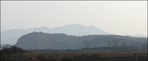 압록강에서 바라본 백마산성. 뒤쪽에 희미하게 보는 것이 의주 삼각산이다.