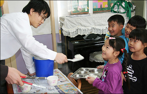  현아가 처음으로 학교 급식 먹는 날, 진명식 선생님은 현아가 얼마만큼 먹는지 몰라서 주걱으로 밥을 풀 때마다 "현아야, 더?" 하고 물었다. 