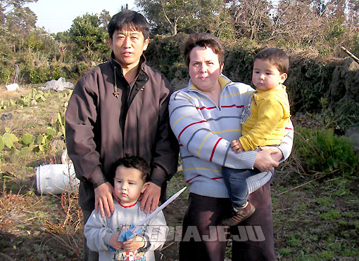 정희수씨와 나탈리아씨가 텃밭을 보여주고 있는 가운데  두 아들 지윤(왼쪽), 성우와 함께 가족사진을 찍었다.