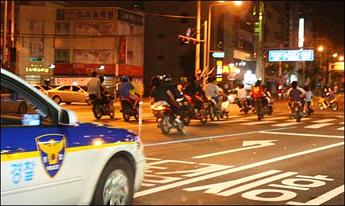 광복절을 맞아 오토바이 폭주에 대한 경찰의 대대적인 단속이 진행된 2007년 8월 15일 새벽 경찰 차량이 서울 동작구 보라매역 인근 도로에서 한 무리의 오토바이 폭주족들을 추격하고 있다.