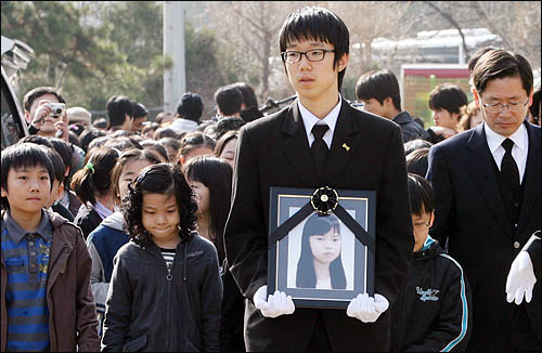  실종된지 두 달여만에 숨진 채 발견된 이혜진양의 영정이 17일 오전 안양 명학초등학교에서 열린 영결식에서 친구들의 배웅을 받고 있다.