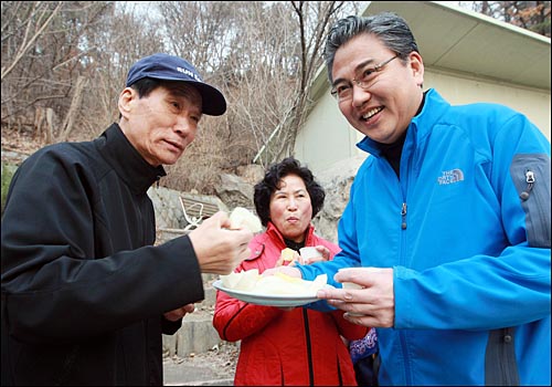 박진 한나라당 의원이 19일 오전 서울 종로구 청운 약수터를 찾아 지역 주민들에게 자신에 대한 지지를 호소하며 과일을 나눠 먹고 있다.