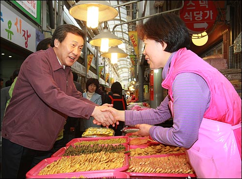 손학규 통합민주당 대표가 19일 오전 서울 강북구 수유시장을 방문하여 시장 상인에게 자신에 대한 지지를 호소하며 악수를 하고 있다.