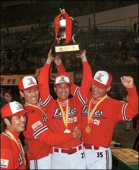 우승 1999년 우승. 주장인 강석천 선수(왼쪽에서 두 번째)가 송진우(가운데)와 함께 우승컵을 들어올리고 있다.