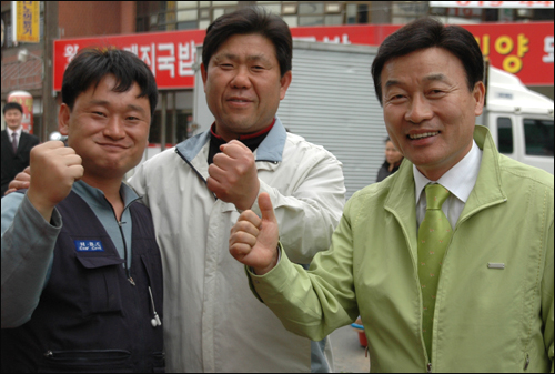 통합민주당 최철국 후보가 22일 오후 김해시장 골목에서 유권자들을 만나 인사를 나눈 뒤 손을 들어 '화이팅'을 외쳤다.