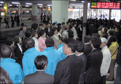 동대구역 승강장에서 사람들이 박근혜 전 대표의 도착을 기다리고 있다. 하늘색 점퍼를 입고 도열해 있는 한나라당 공천자들의 모습이 인상적이다. 