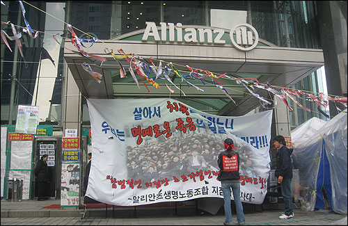 2일 찾은 서울 여의도 알리안츠생명 본사 입구. 회사가 고용한 경호업체 직원들이 입구를 막아서고 있는 가운데, 알리안츠생명 노조에서 마련한 큰 걸개그림이 시선을 사로잡고 있다.