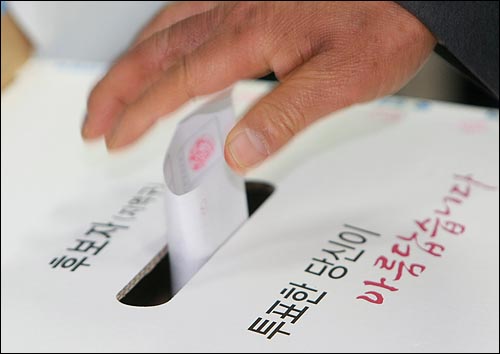 제18대 국회의원선거일인 9일 오전 서울 공덕동 어린이집에 마련된 공덕동제6투표소에서 시민이 투표함에 투표용지를 넣고 있다.