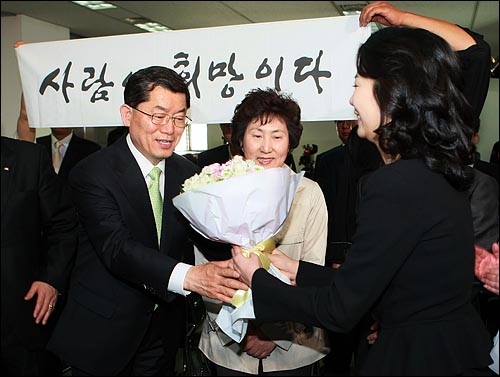 문국현 창조한국당 후보가 9일 오후 서울 영등포구 당사에서 당선이 확실시 되자 당직자로부터 축하의 꽃다발을 받고 있다.