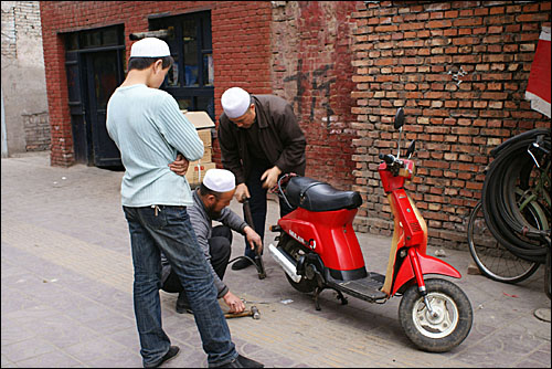 조만간 철거될 자전거 수리점포 앞에서 오토바이를 수리하는 회족 상인. 회족이 많이 거주하는 중국 서북부 지역이 고도의 경제 성장에 소외되면서 회족 사이에 불만이 늘고 있다.