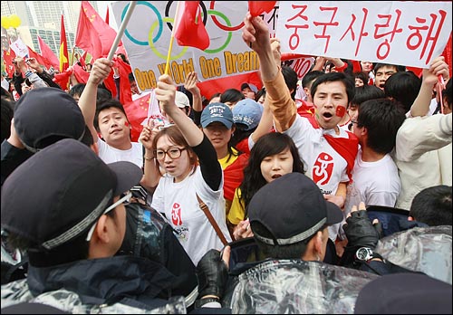 중국 유학생들이 27일 오후 서울 송파구 올림픽공원 평화의 문 광장앞에서 성화가 출발한 뒤 중국의 인권 탄압에 반대하는 시민단체 회원들과 충돌이 벌어지자 경찰들이 저지하고 있다.