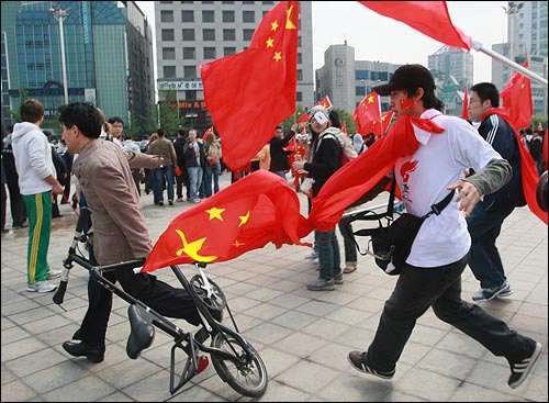중국 유학생들이 27일 오후 서울 송파구 올림픽공원 평화의 문 광장앞에서 성화가 출발한 뒤 시민들과 충돌하여 오성홍기를 휘두르고 있다.