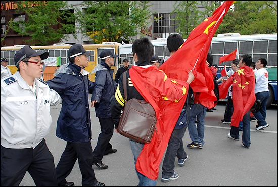 중국인 유학생들이 베이징 올림픽 성화 봉송을 반대 집회를 열고있던 시민단체 행사장 달려가자 경찰들이 이를 저지하고 있다.