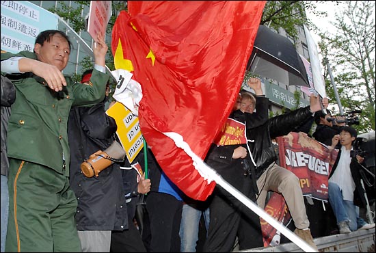 중국인 유학생들이 베이징 올림픽 성화 봉송을 반대 집회를 열고있던 시민단체 회원들을 향해 각목을 휘두르고 있다.