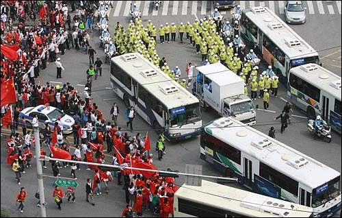 27일 오후 서울 올림픽공원 평화의 광장을 출발한 북경올림픽 성화 주자를 경찰이 경찰버스와 병력을 동원해서 겹겹이 에워싸고 있다.