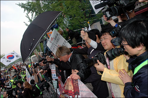 중국 유학생들의 공격을 우산 등을 펼쳐든 채 맞서고 있는 '성화봉송' 저지 시민단체 회원들  