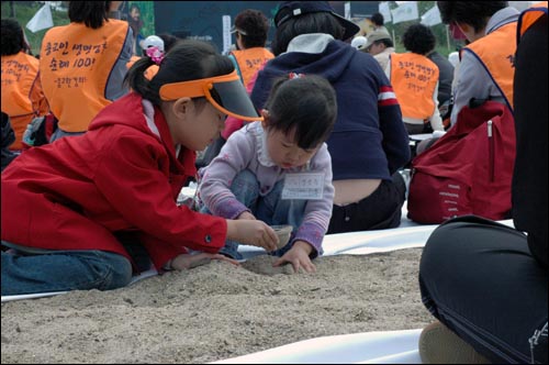  정토회 행사장에서 모래를 가지고 노는 어린 자매