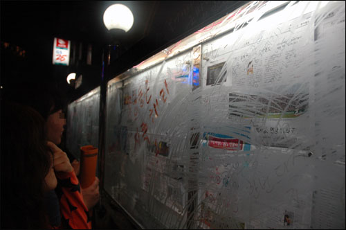 동아일보에 분노한 시민들이 신문 게시판에 낙서를 하고 있다. 