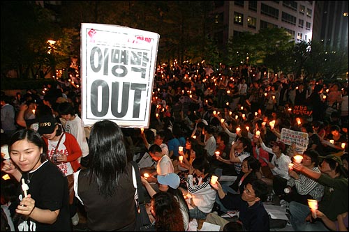 미국산 쇠고기 수입 전면 개방을 반대하는 학생과 시민들이 3일 저녁 서울 청계광장에서 촛불문화제를 열고 있다. 교복을 입고 집회에 참석한 여학생들 이명박 대통령을 규탄하는 피켓을 들고 있다. 