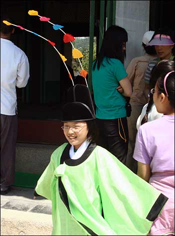 훈민정음 서문 쓰기 행사에 참여한 한 아이가 어사화를 쓰고 활짝 웃고 있다.