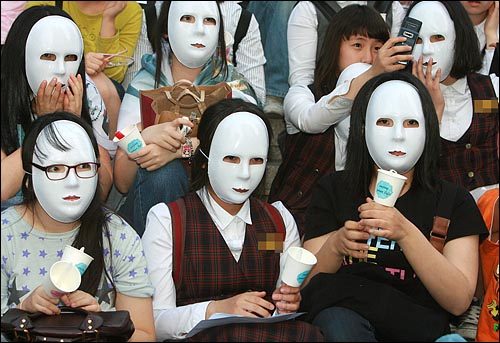 사진은 5월 2일 저녁 서울 청계광장에서 열린 미국산 쇠고기 수입 전면 개방을 반대하는 촛불문화제에서 교복을 입은 여학생들이 마스크를 쓰고 참여하고 있다.