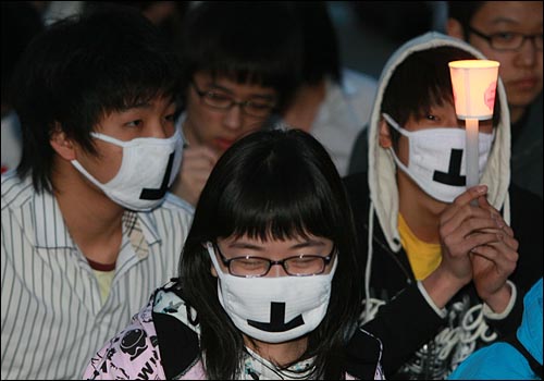 '이명박 탄핵을 위한 범국민운동본부' 주최로 6일 저녁 서울 여의도 공원 앞에서 열린 촛불문화제에서 학생들이 정부의 미국산 쇠고기 수입 정책 철회를 촉구하며 촛불을 들고 침묵시위를 하고 있다.