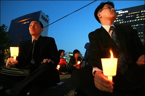 양복을 입은 직장인들이 6일 저녁 서울 청계광장에서 열리는 미국산 쇠고기 전면 개방을 반대하는 촛불문화제에 참여하고 있다.