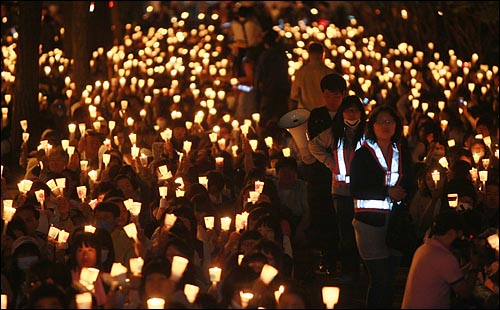 미국산 쇠고기 수입 전면 개방을 반대하는 학생과 시민들이 6일 저녁 서울 여의도 공원 앞에서 열린 촛불문화제에서 정부의 미국산 쇠고기 수입 정책 철회를 촉구하며 촛불을 들고 침묵시위를 하고 있다. 