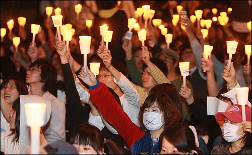 미국산 쇠고기 수입 전면 개방을 반대하는 학생과 시민들이 6일 저녁 서울 여의도 공원 앞에서 열린 촛불문화제에서 정부의 미국산 쇠고기 수입 정책 철회를 촉구하며 촛불을 들고 침묵시위를 하고 있다.
