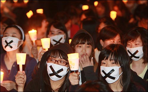  미국산 쇠고기 수입 전면 개방을 반대하는 학생과 시민들이 6일 저녁 서울 여의도 공원 앞에서 열린 촛불문화제에서 정부의 미국산 쇠고기 수입 정책 철회를 촉구하며 촛불을 붙이고 있다.