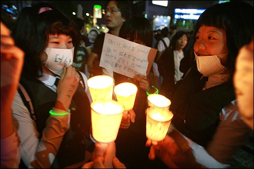 6일 저녁 서울 청계광장에서 열린 미국산 쇠고기 전면 개방을 반대하는 촛불문화제에서 촛불을 든 여중생들이 모여 이야기를 나누고 있다.