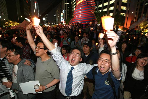 6일 저녁 서울 청계광장에서 열린 미국산 쇠고기 전면 개방 반대 촛불문화제에서 촛불을 든 시민들이 어깨동무를 한 채 흥겨운 노래를 부르고 있다.