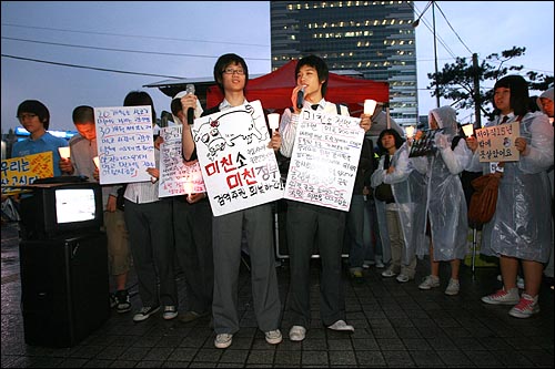 7일 저녁 서울 청계광장에서 비가 내리는 가운데 열린 미국산 쇠고기 전면 수입개방 반대 촛불문화제에서 고등학생들이 직접 제작한 피켓을 들고 나와 발언을 하고 있다.